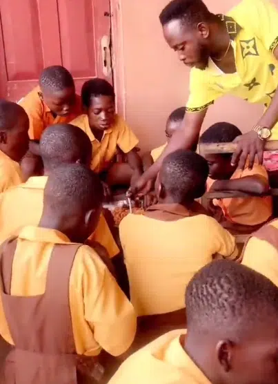 Teacher touches hearts as he uses his salary to cook Jollof Rice and Chicken for his students