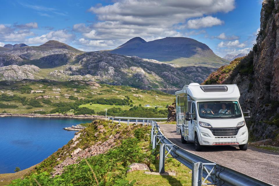 2AHBJ34 Campervan on a winding road in the Scottish Highlands, with Sail Gharbh capped in low cloud in the background