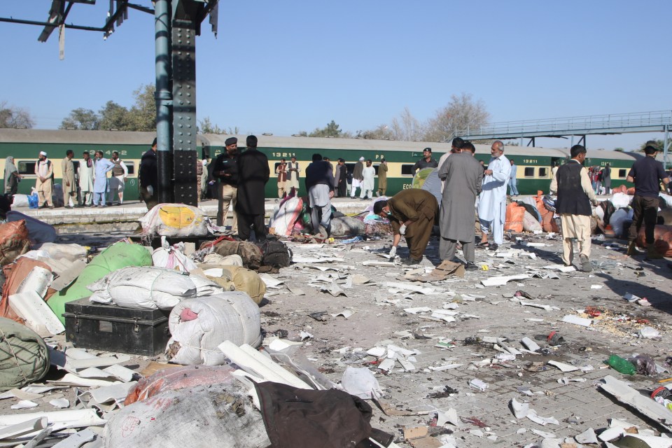 Plain-clothed police officers survey the site following the explosion