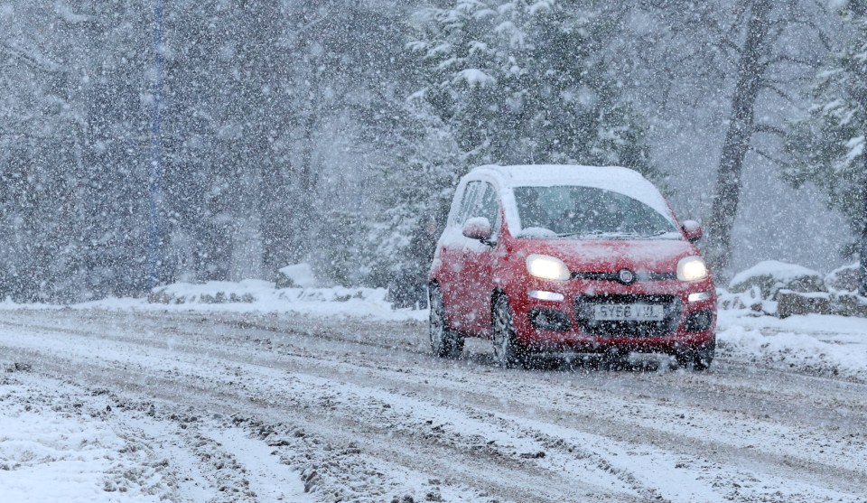 A car drives through the snow in Aviemore, Scotland, yesterday