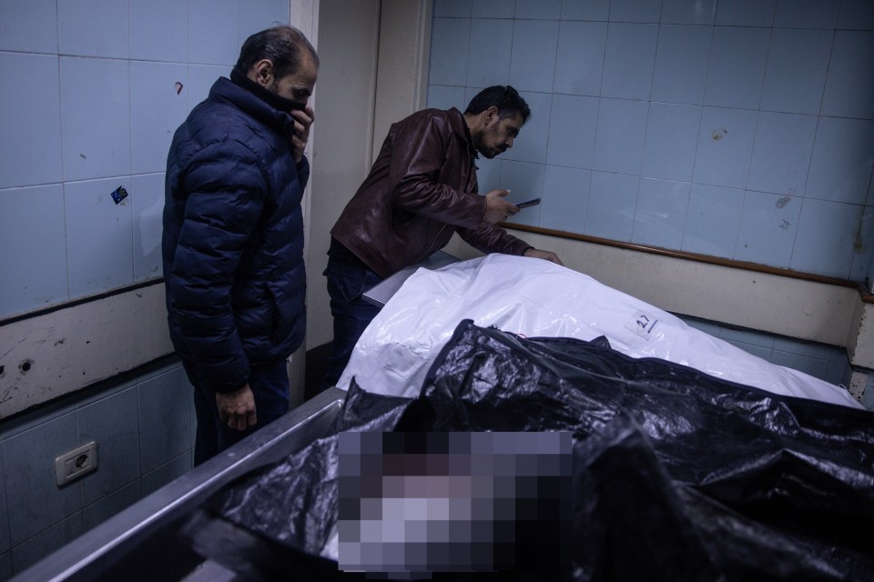 Men checking body bags for any sign of their family and friends