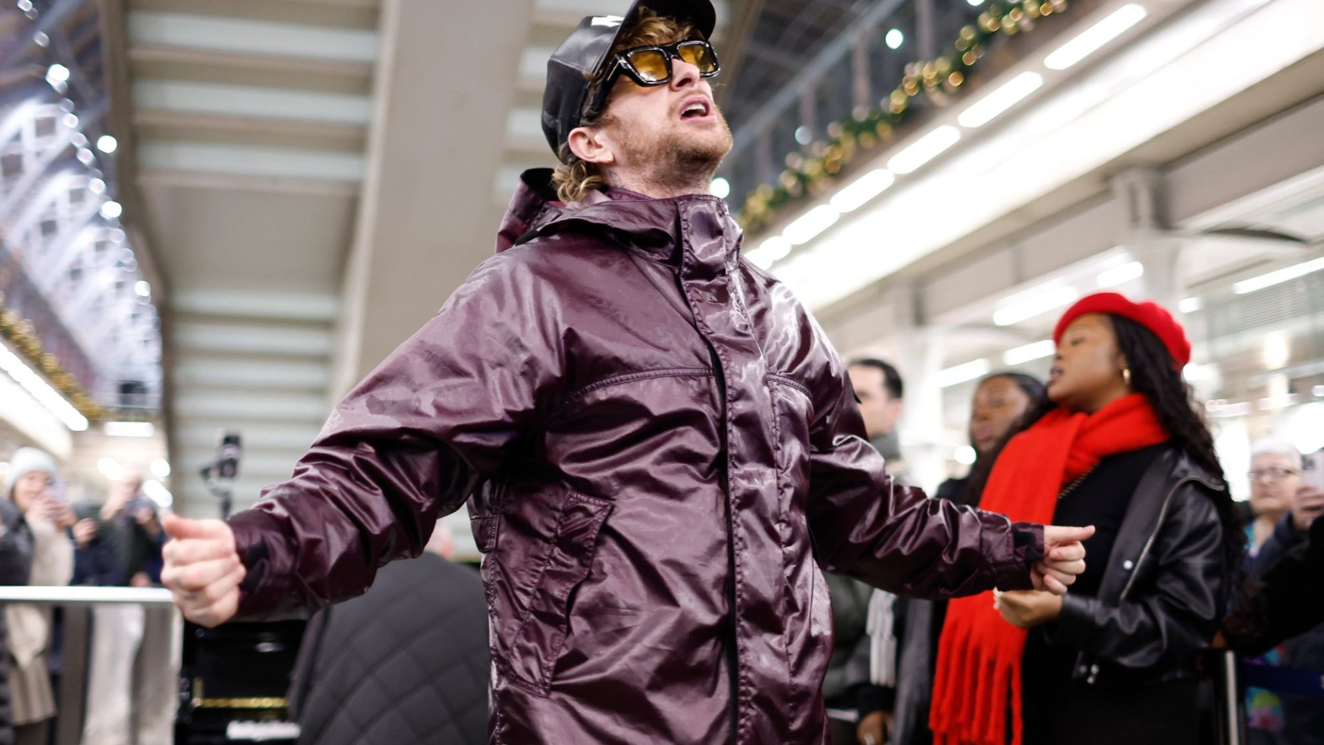 Watch the moment pop superstar stuns onlookers & brings busy train station to a standstill in bid for Christmas number 1