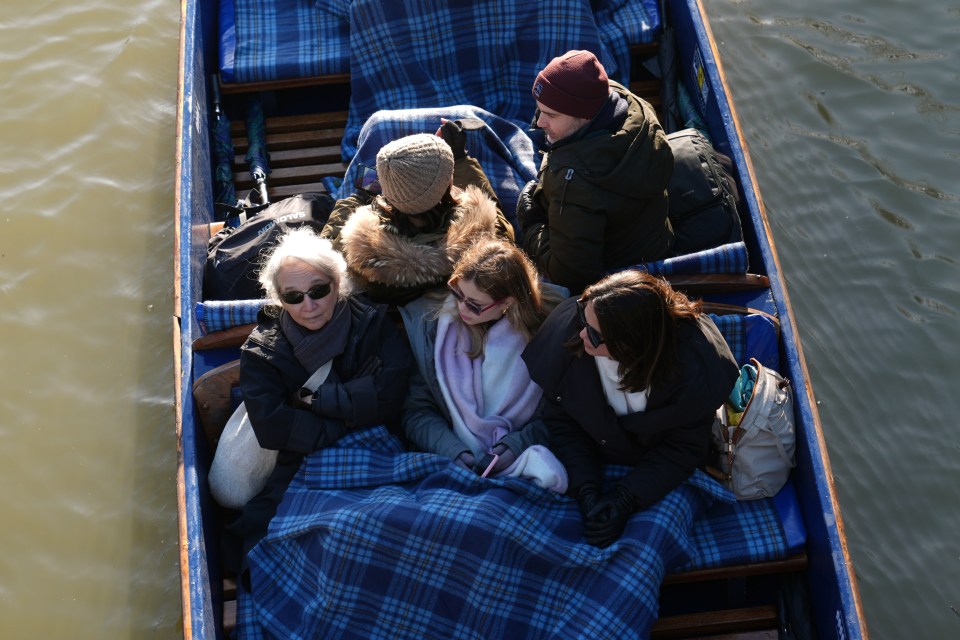 People wrap up warm as they punt along River Cam on a cold day in Cambridge