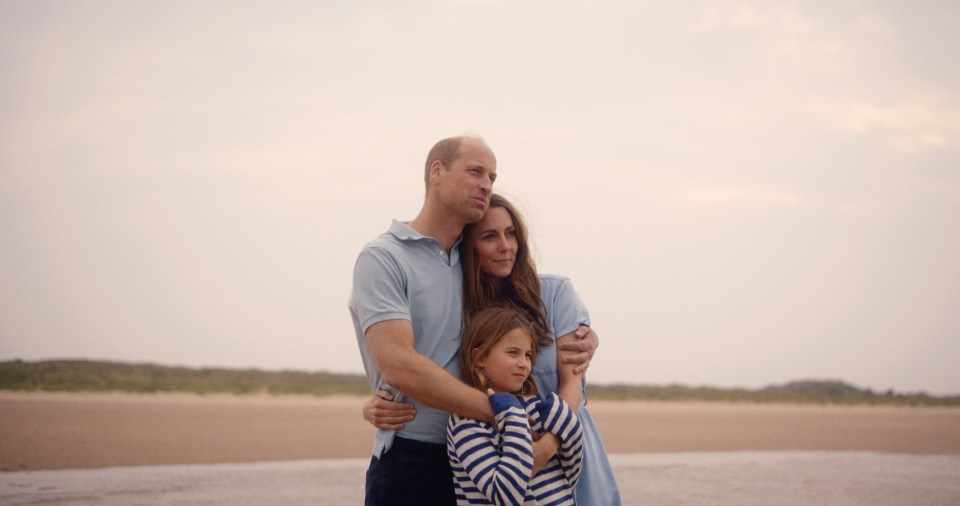 The Prince and Princess of Wales and Princess Charlotte on a beach.