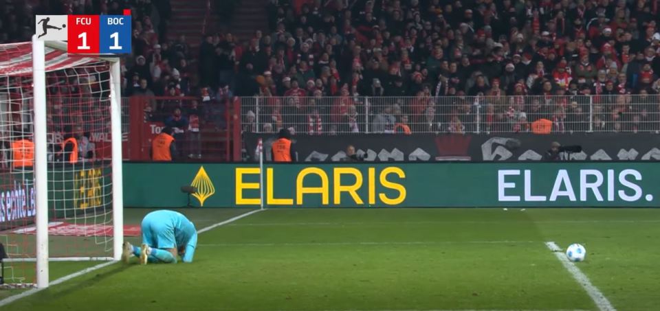 Soccer goalkeeper kneeling on the field after a goal; the score is 1-1.