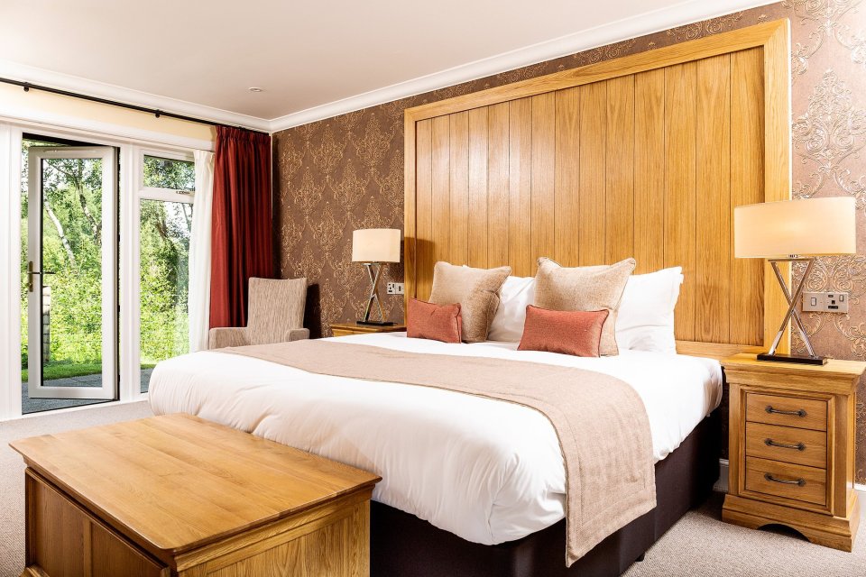 Hotel room with king-size bed and wooden headboard.