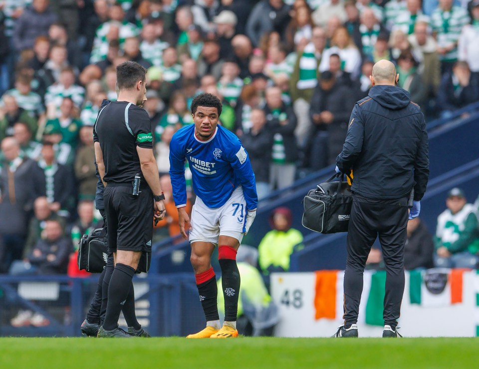 Soccer player with a hamstring injury being attended to by medical staff.