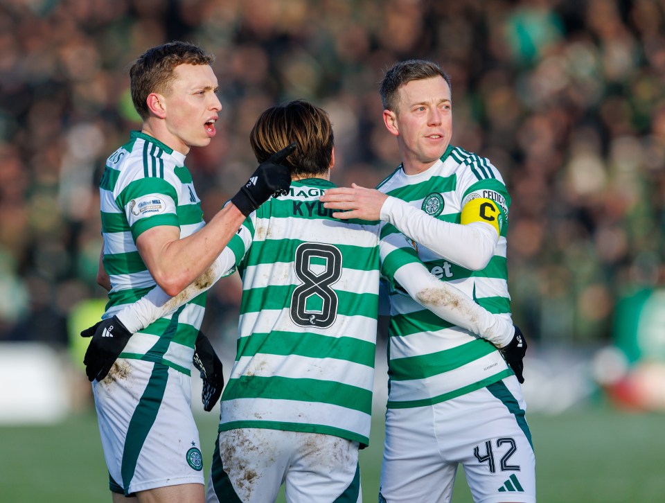 Three Celtic soccer players celebrating a goal.