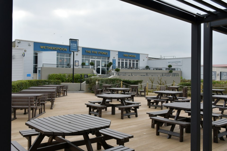 Exterior view of The Five Stones pub, a Wetherspoon's pub, with outdoor seating.