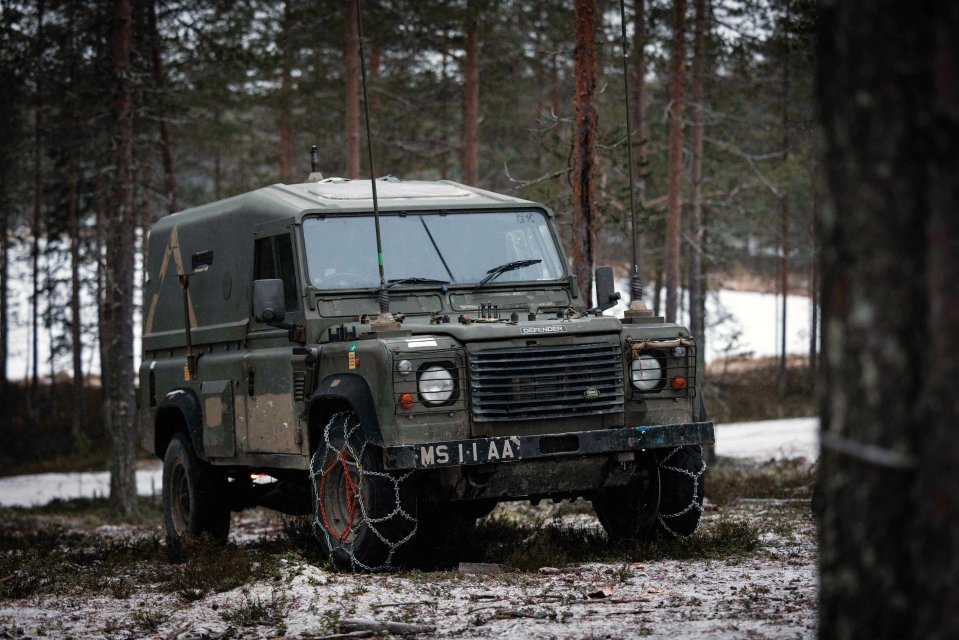 British Army Land Rover in snowy forest.