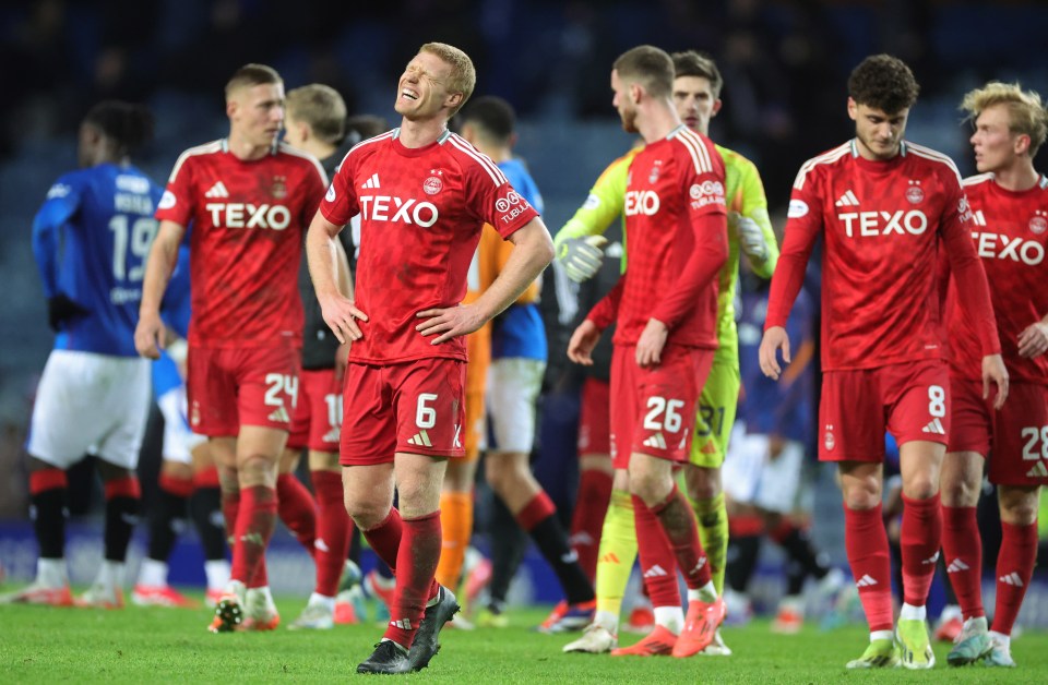 Disappointed Aberdeen soccer players on the field.