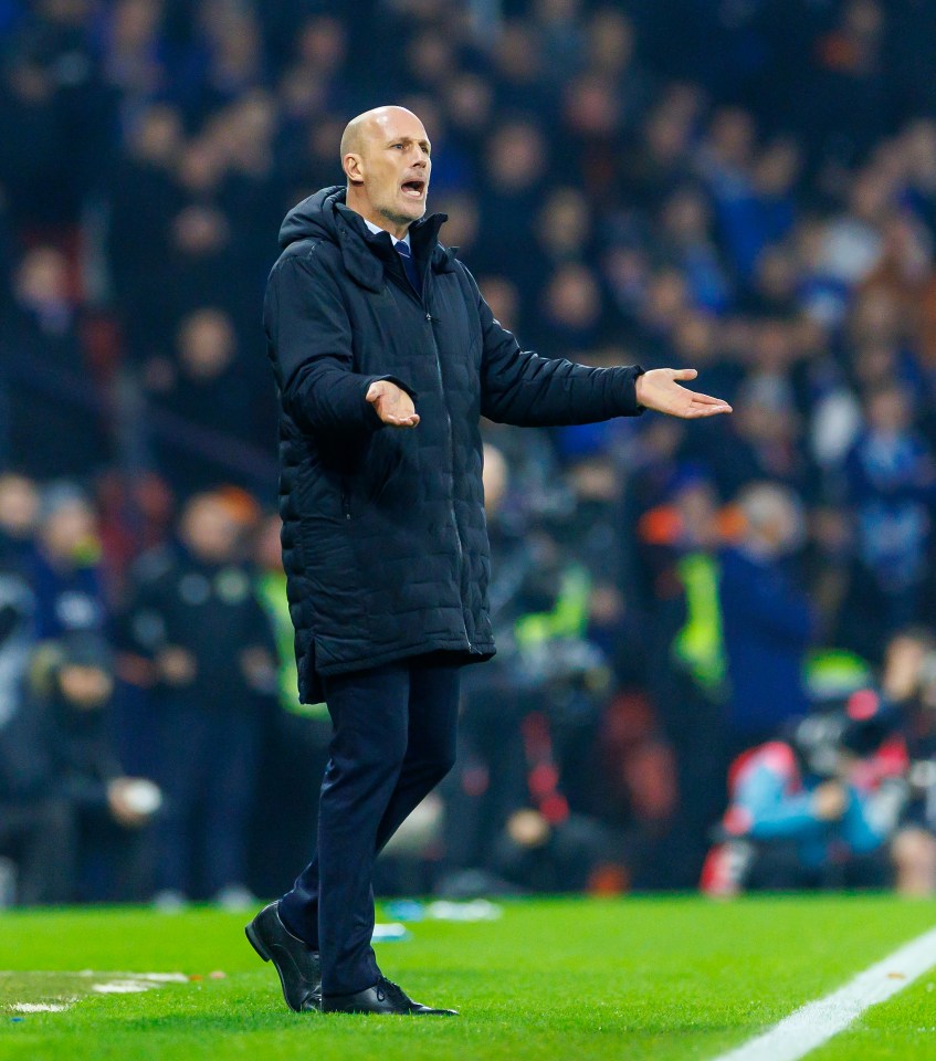 A soccer coach on the sidelines, gesturing.